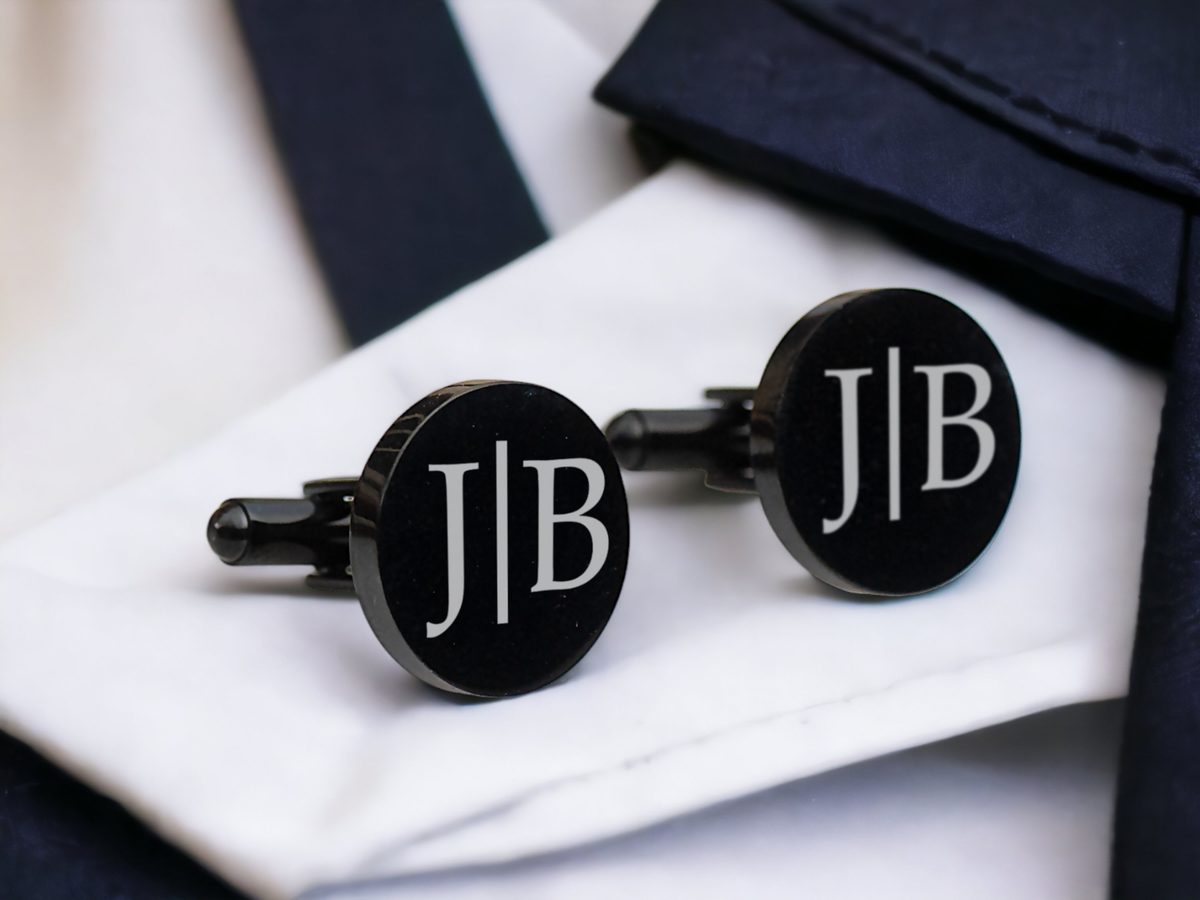 Visiškai juodos apvalios sąsagos su monograma „J | B“ ant balto rankogalio